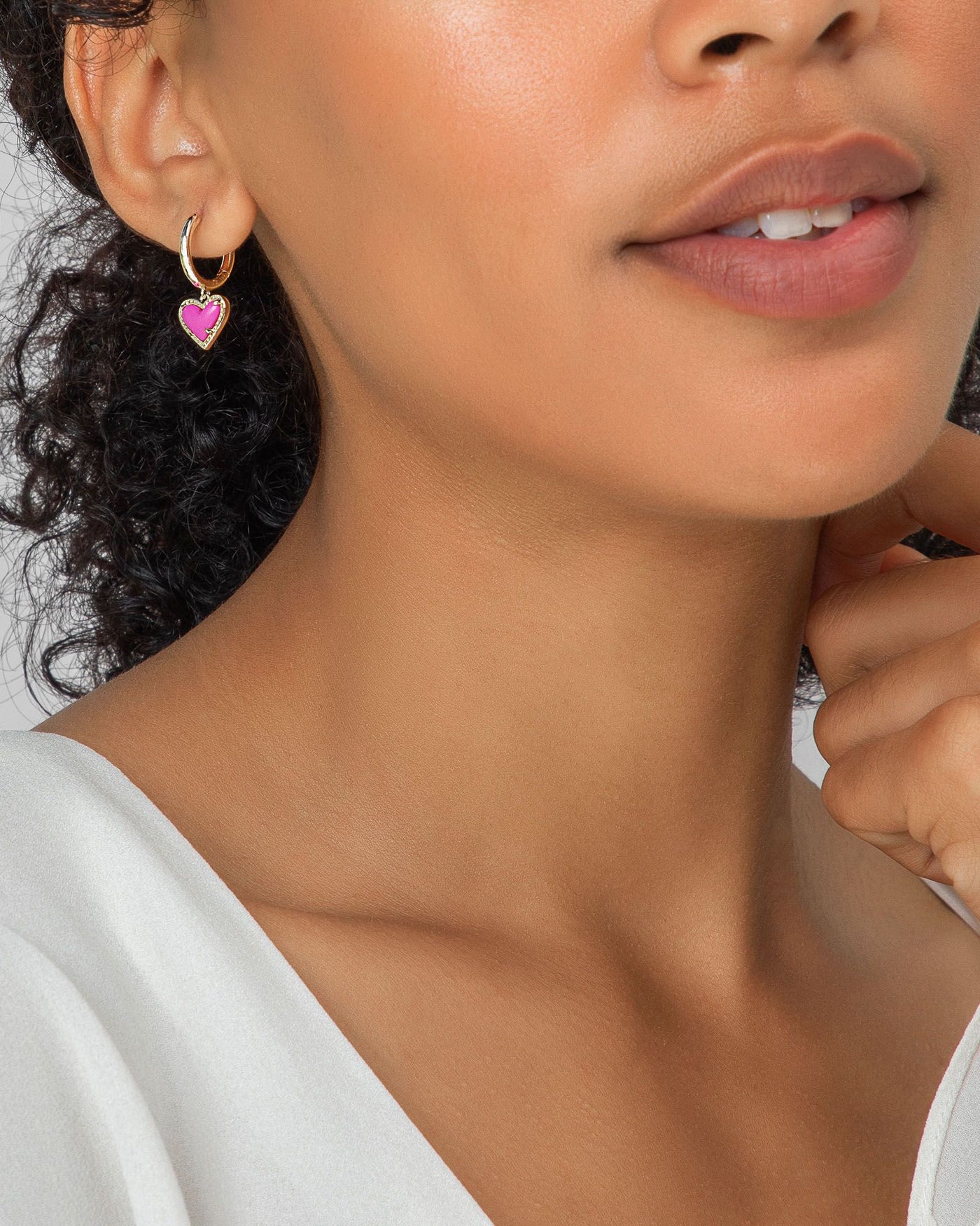 Kendra Scott Ari Heart Huggie Hoops in Gold Iridescent Drusy on model.