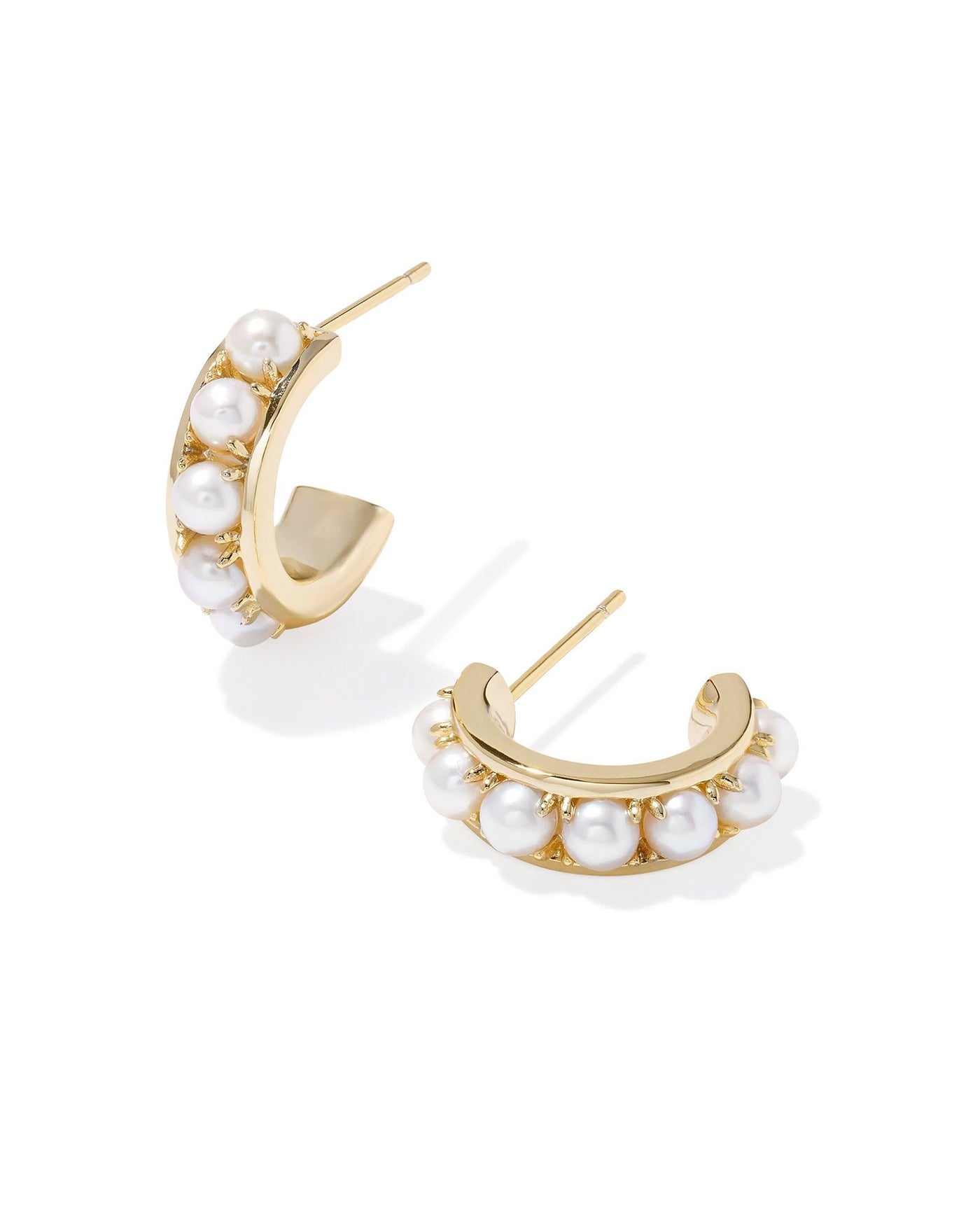 White pearl studded gold huggie hoops.