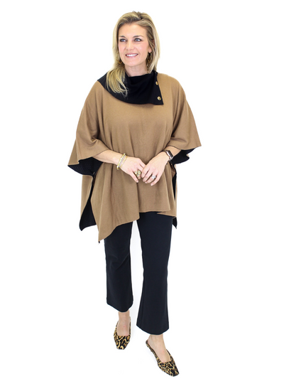 Black and tan poncho with gold buttons on model, front full view.