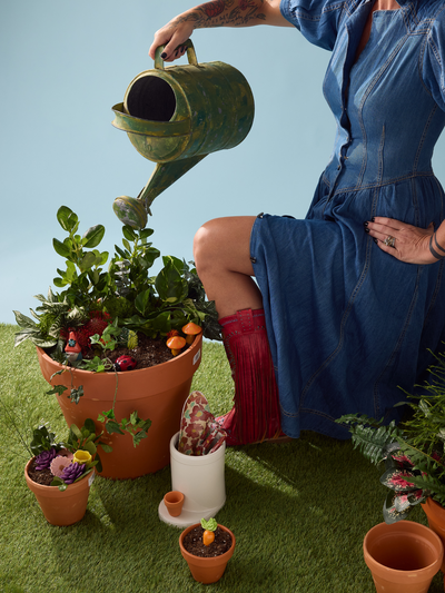 Woman watering plants in flower pots.