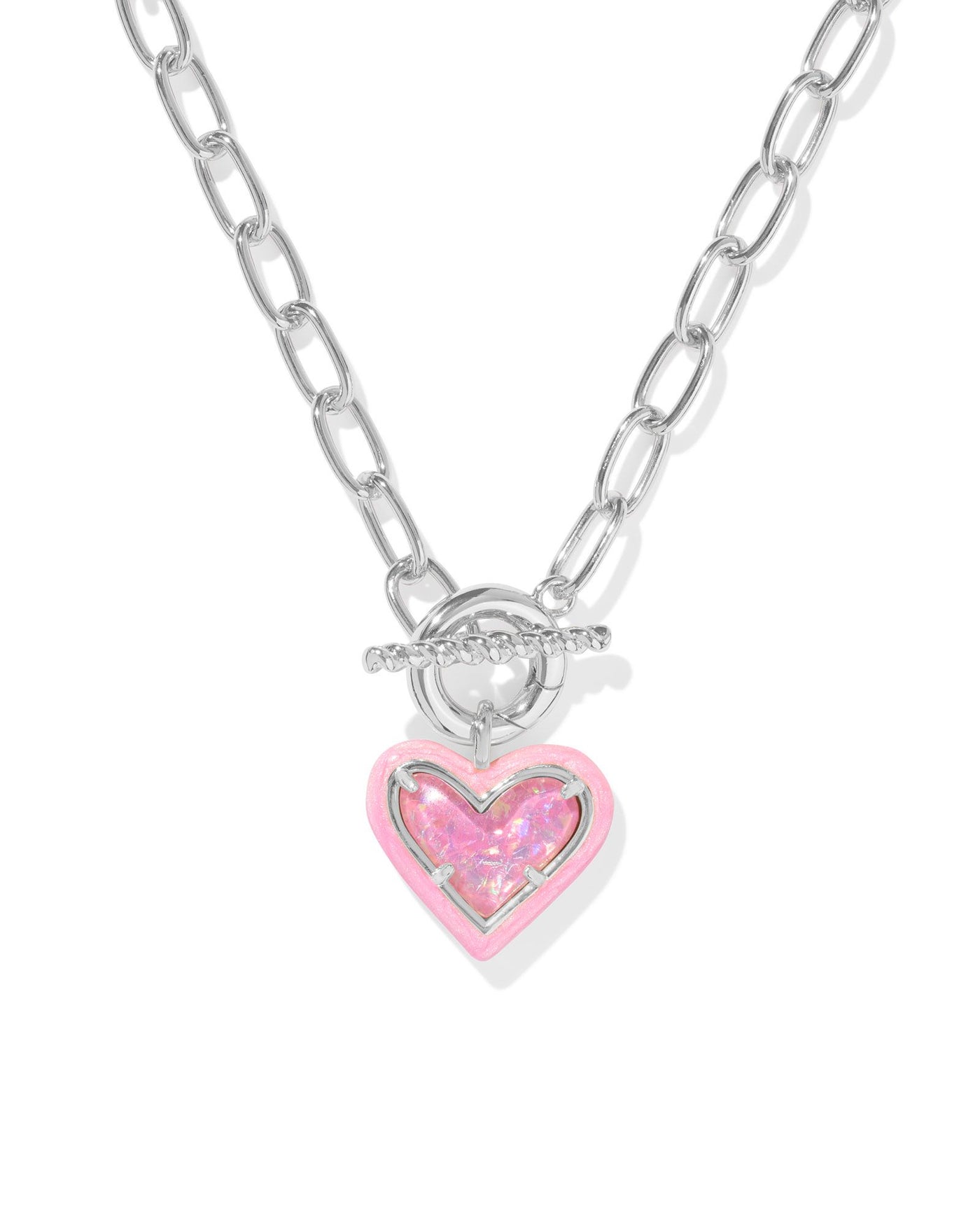 Silver link chain necklace with pink enamel framed pink iridescent glitter glass heart pendant, closeup.