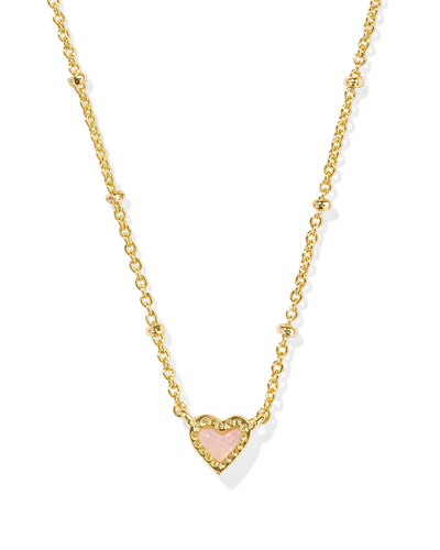 Gold necklace with rose quartz heart pendant, closeup.