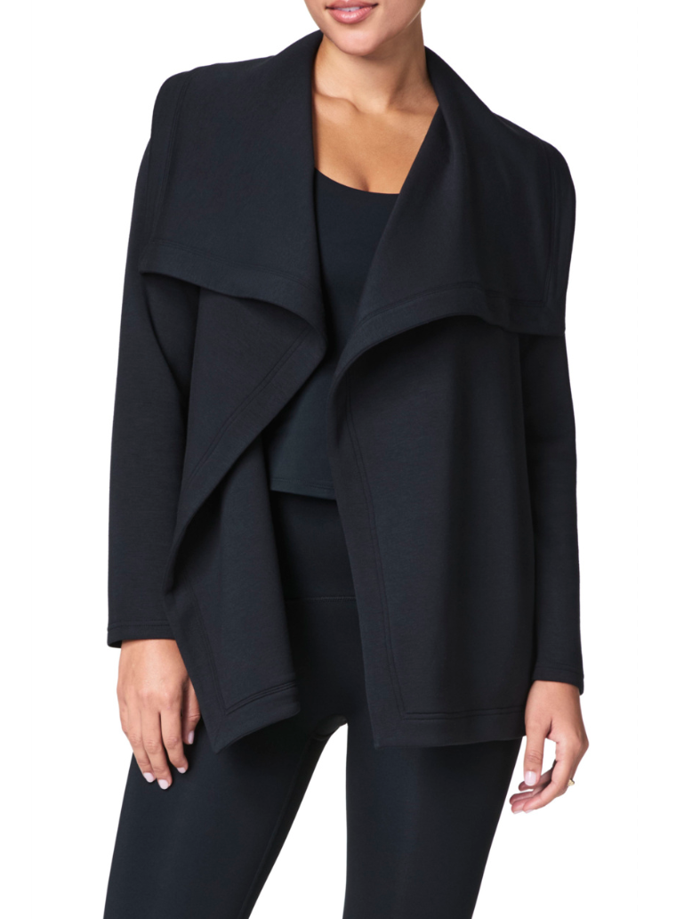 Black drape snap-front cardigan on model, front view.