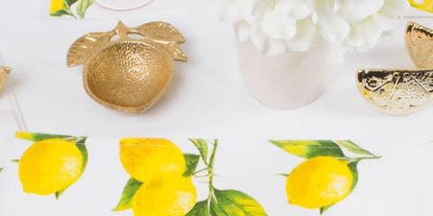 Gold painted metal trinket dish in the shape of a lemon with leaves on it