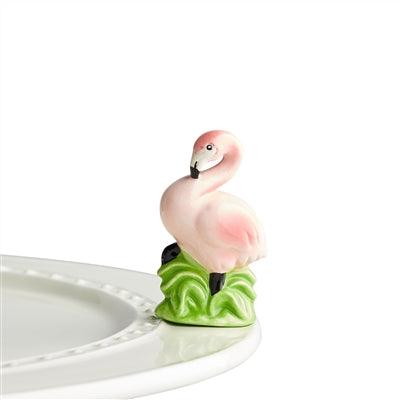 Pink flamingo standing in tall green grass mini