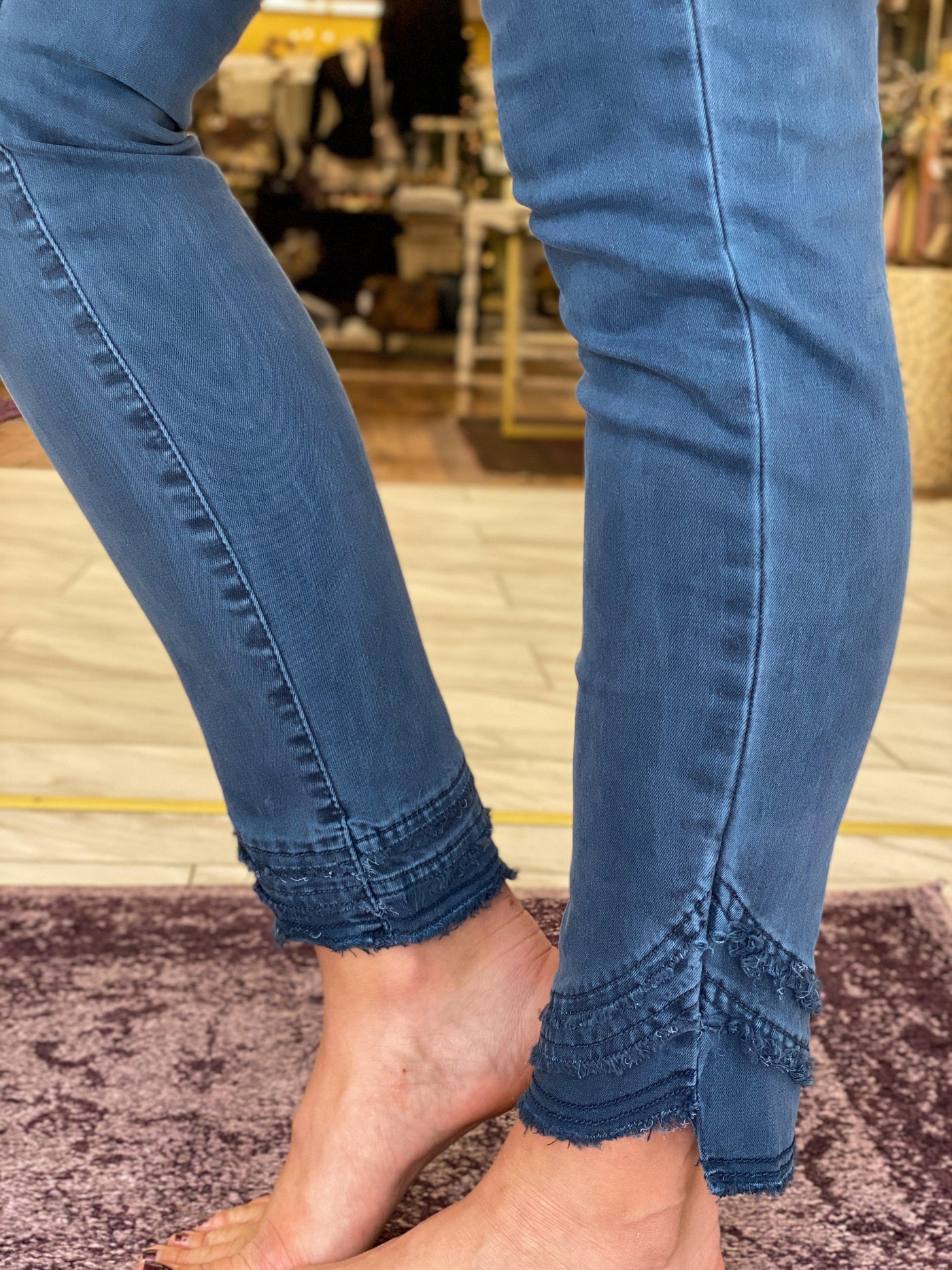 Up close of frayed edge hem detail on Charlie B balsam denim pants. 