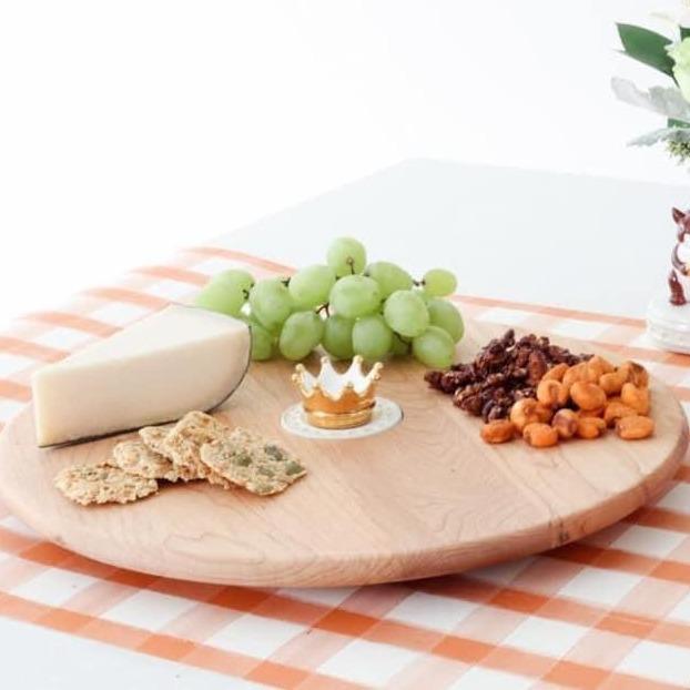 Maple wood lazy susan with food on top and a gold crown mini